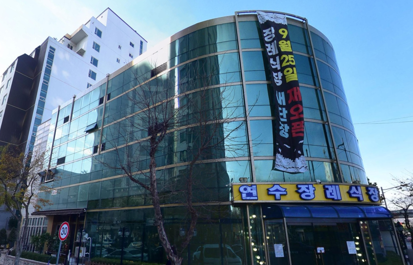 연수장례식장 유리 건물과 노란 간판 연수장례식장 원형 유리 외벽과 간판 모습