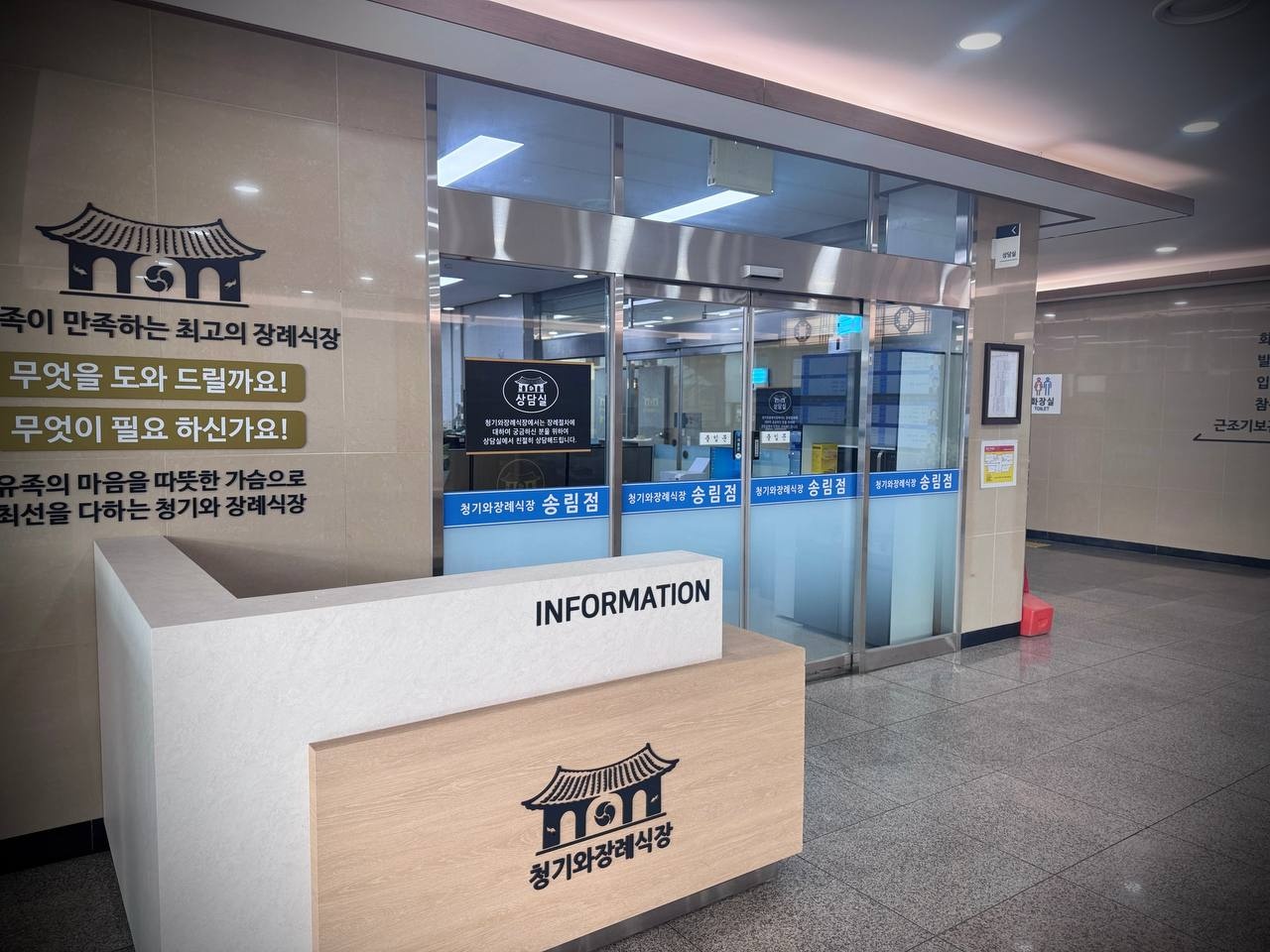 인천청기와장례식장 안내데스크와 유리 출입문 인천청기와장례식장 로비 안내데스크 모습