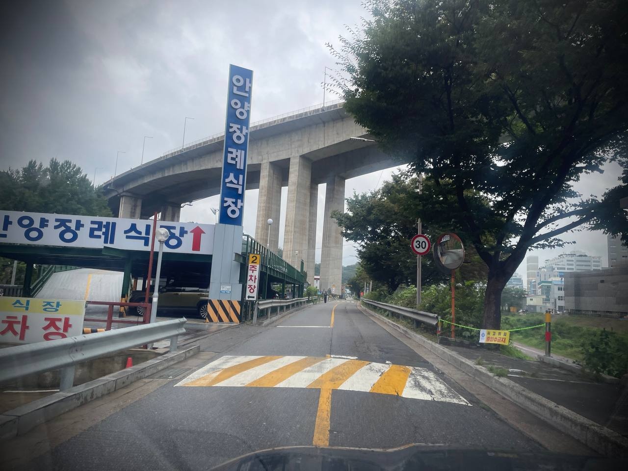 안양장례식장 고가도로 아래 진입로 안내 표지 안양장례식장 진입로와 안내 표지가 보인다.