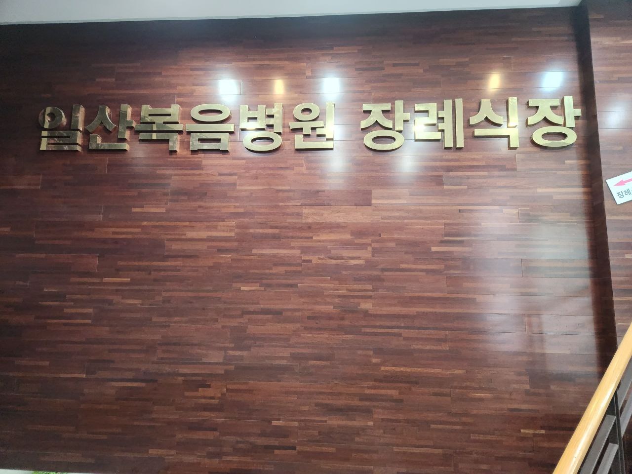 일산복음병원장례식장 목재 벽면 금색 간판 목재 벽면의 일산복음병원장례식장 간판 사진