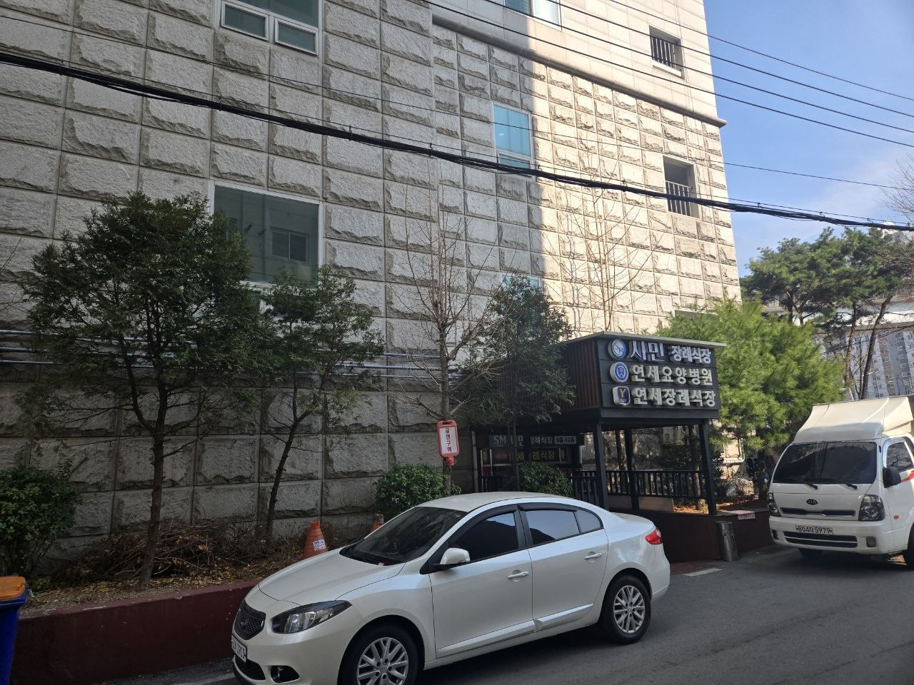 건물 측면과 차량 주차 모습