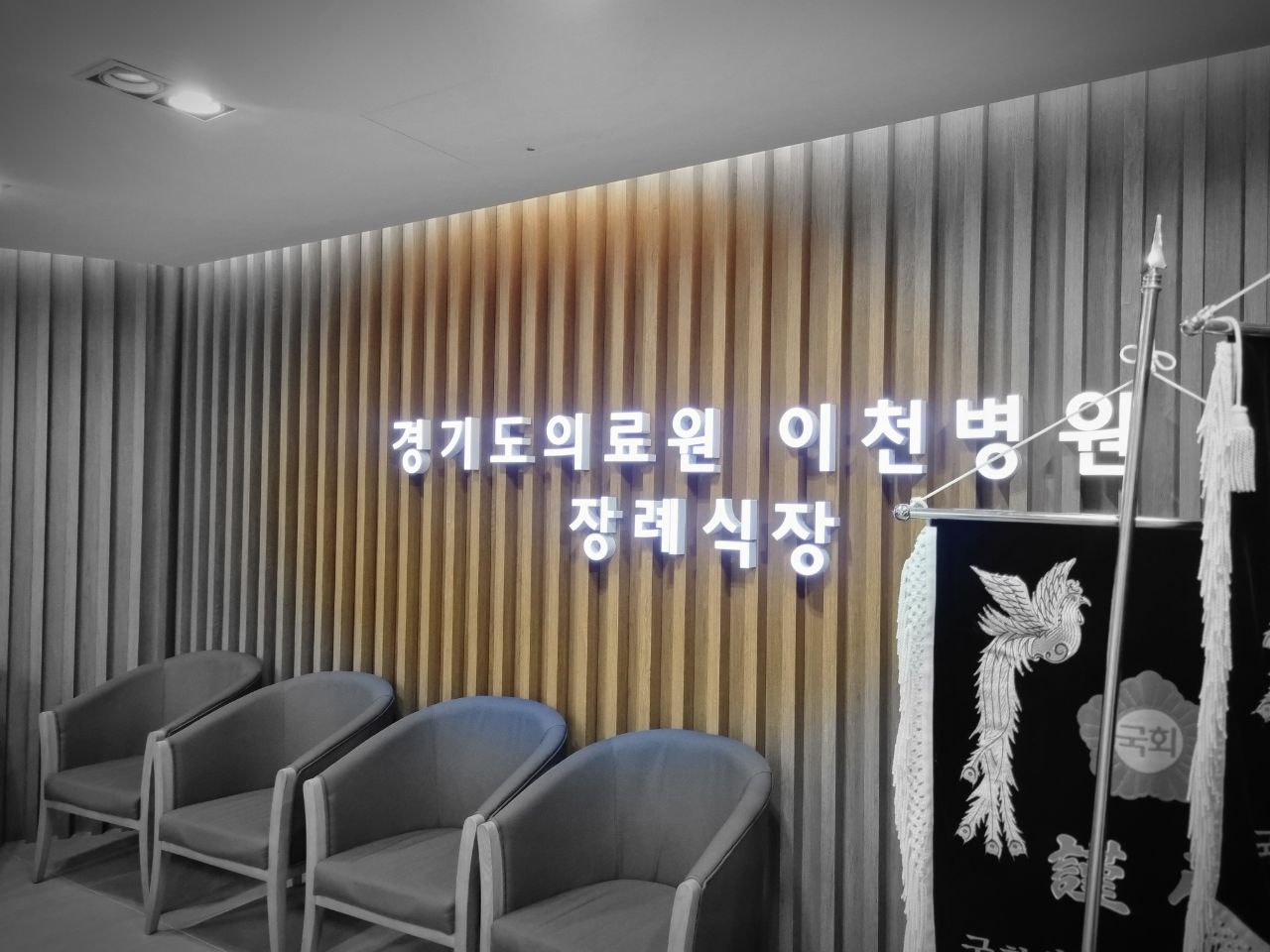이천의료원장례식장 실내 명판과 좌석 공간 이천의료원장례식장 명판과 근조기가 놓인 실내