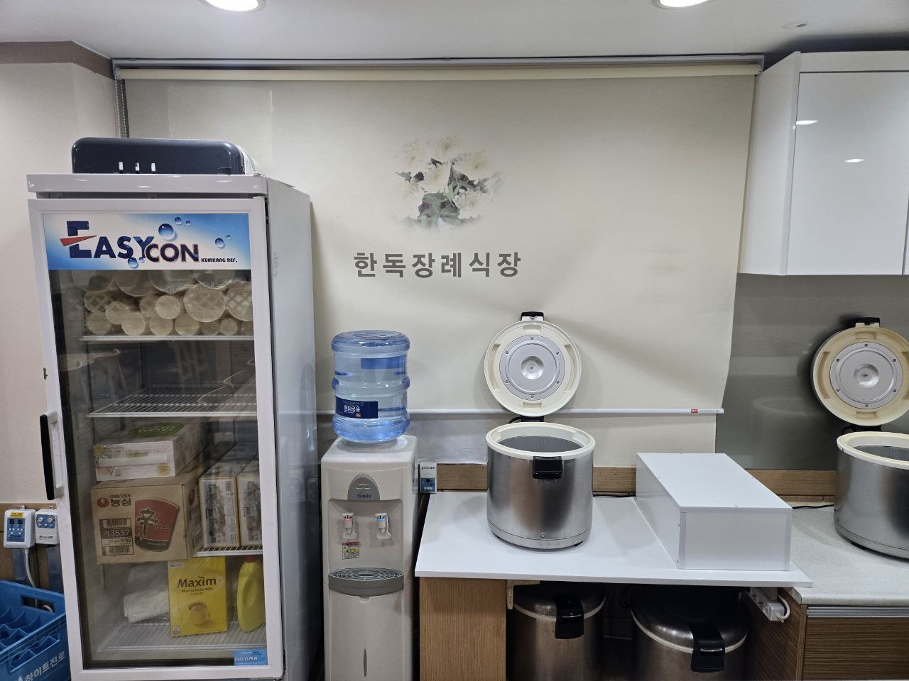 수원한독병원장례식장 식당 급수대와 보온밥솥 공간 식당에 냉장고와 보온밥솥이 보인다.