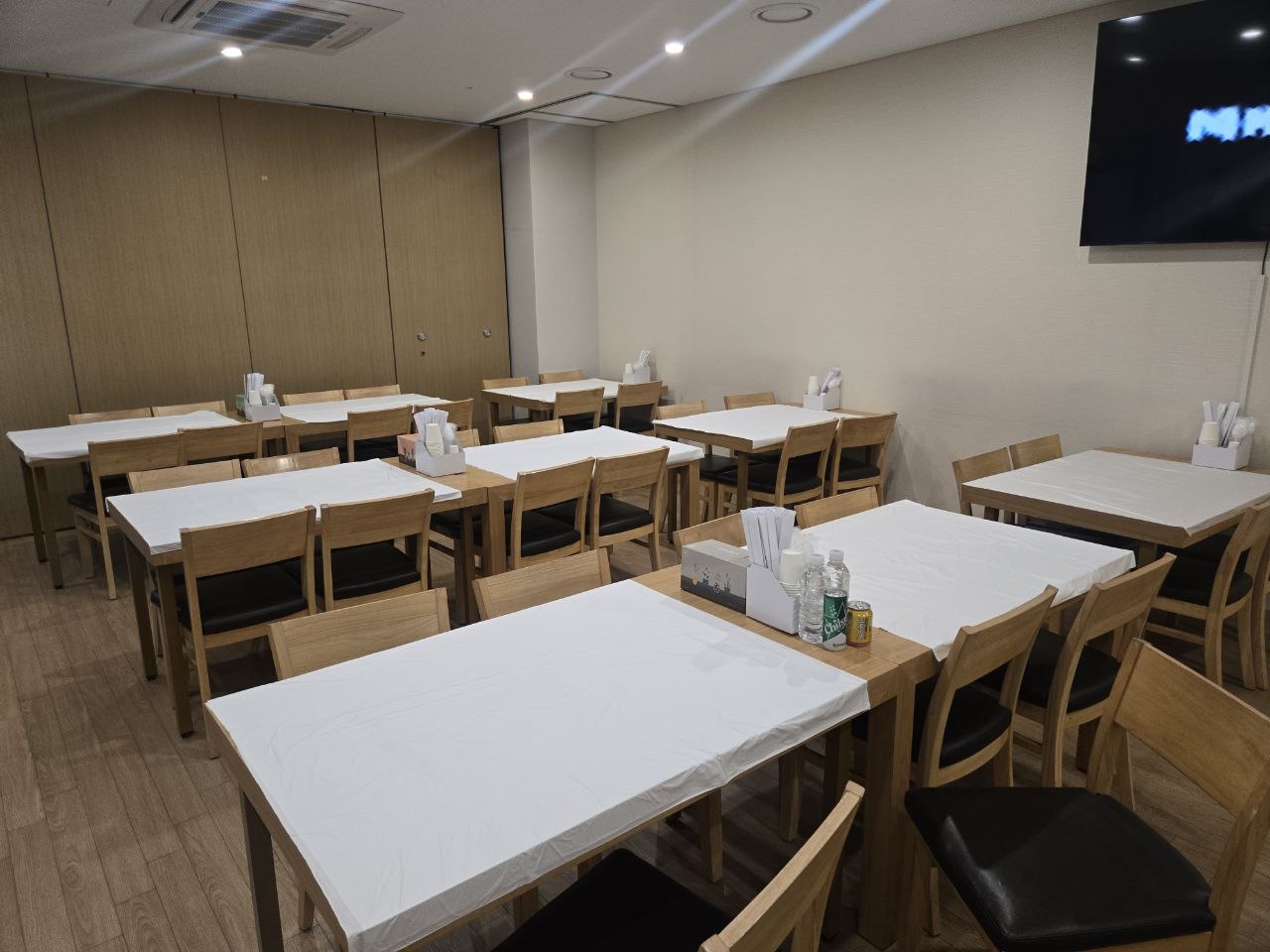 이대서울병원장례식장 정돈된 식당 좌석 공간 식당에 테이블과 의자가 정돈되어 있다.